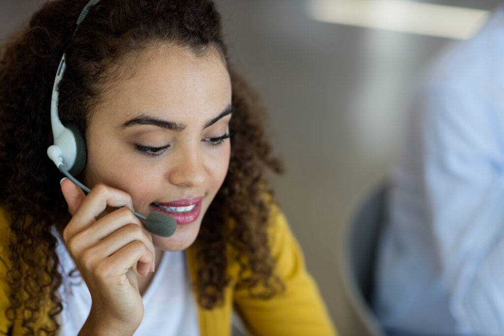 Customer service executive wearing a headset, assisting clients in a modern office – professional support for cleaning services in Hampton Roads.